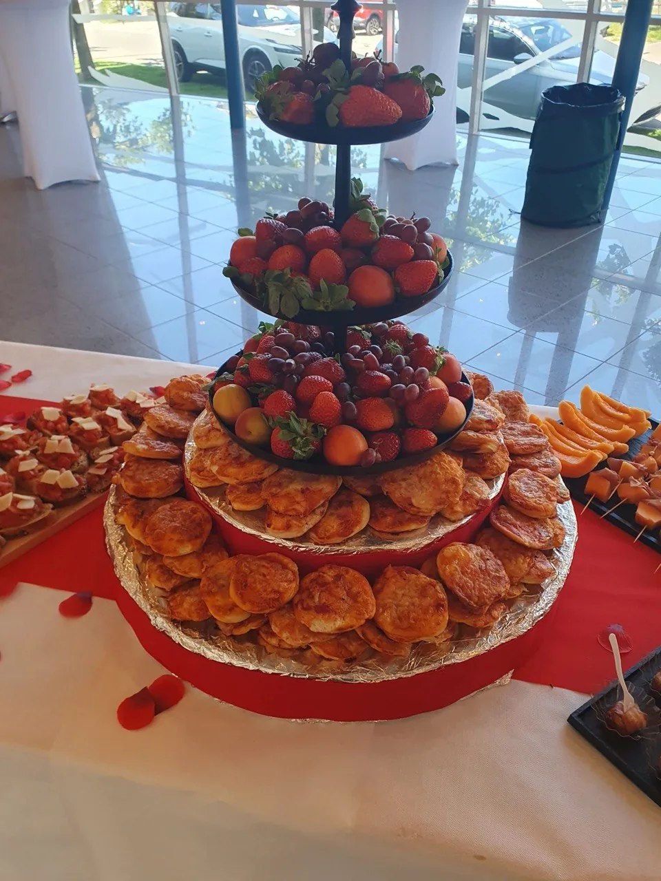 Catering-Etagere mit frischen Tomaten, Blätterteiggebäck und herzhaften Häppchen